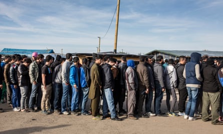 Men queue in line for a handout of clothing