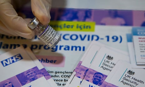 A phial of Pfizer Covid-19 booster vaccine next to an NHS leaflet in a vaccination centre.