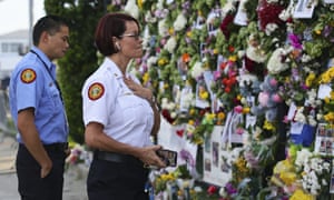 Miami-Dade Fire Rescue personnel Fai Yeung and Chief Melanie C. Adams visit the makeshift memorial setup near the partially collapsed 12-story Champlain Towers South Condo.