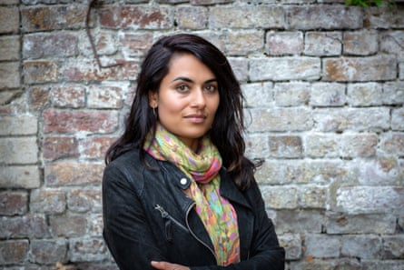 A portrait of a woman with a brick wall behind her