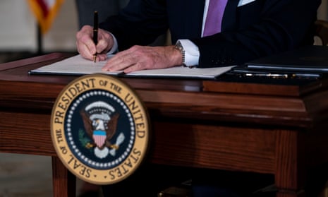 Joe Biden signs executive orders at the White House on 26 January. 