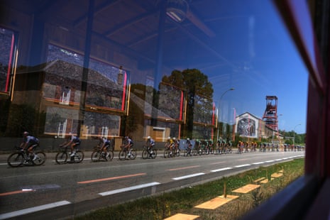 Tour de France riders are reflected in a window
