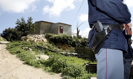 A policeman stands in front the house where a mafia boss was arrested in Sicily, Italy.
