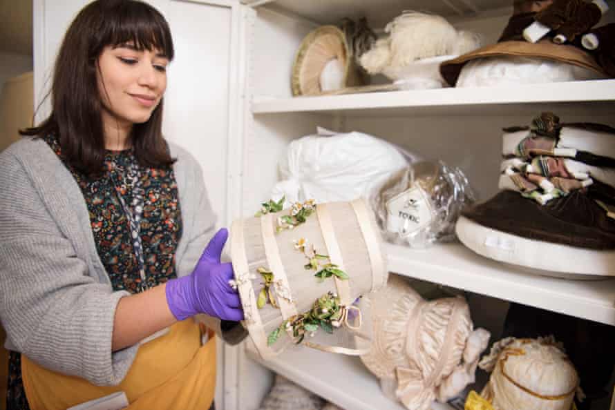 Ruby Hodgson holds a wedding bonnet from 1845 with leaves that might have been dyed with arsenic.