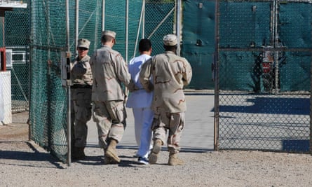 Navy guards escort a detainee through Camp Delta at Guantánamo Bay naval base.