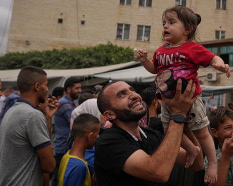 Palestinians celebrate after the announcement that Israel and Hamas have agreed to the first phase of a peace plan to pause the fighting, outside al-Aqsa hospital in Deir al-Balah, central Gaza Strip.