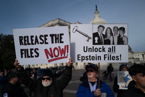 people hold signs that read 'release the files now' and 'unlock all Epstein files'