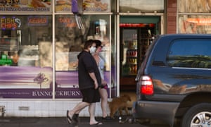 people in masks walk past fish and chip shop in Melbourne