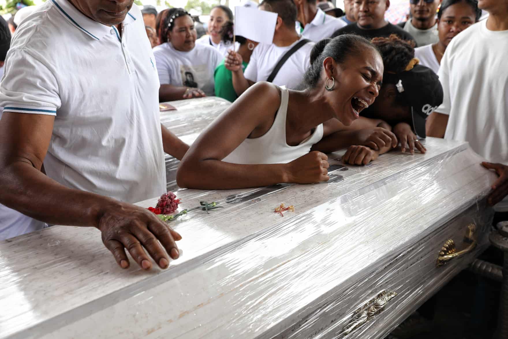 People weeping over a sliver coffin