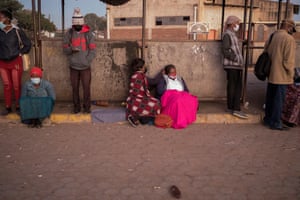 Mupombwi and her friend sit together in the queue