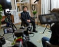 Zelenskyy sits on a chair facing multiple cameras in a living room setting