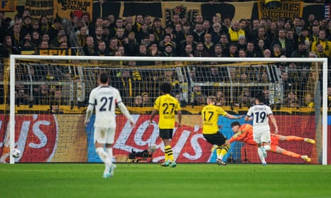 PSG's Lee Kang-in (centre) shoots past Dortmund's goalkeeper Gregor Kobel (right) but also wide of the goal.