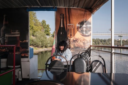 A woman sits at a table in the cabin of a boat