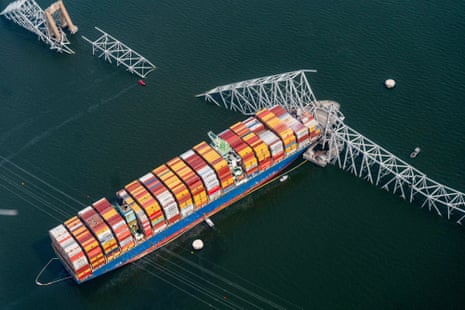 aerial photograph of huge container with collapsed bridge around it