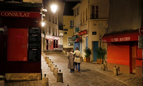 A couple walks on a deserted street at night on the Butte Montmartre in Paris.