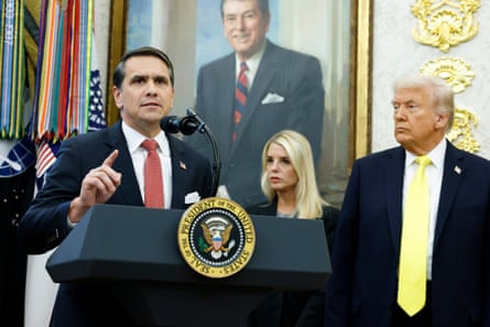 a man and a woman looking at a man in front of a microphone