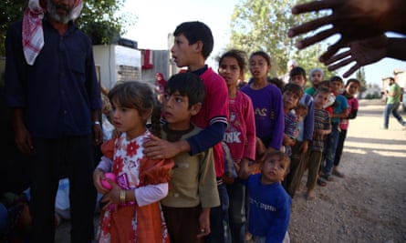 Syrian children queue to receive aid.