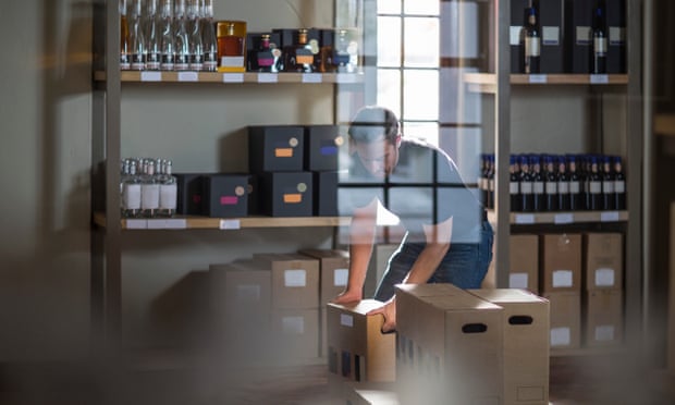 Man packing bottles of wine in shop.
