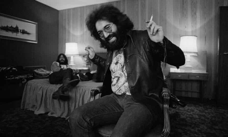 Jerry Garcia with a joint in his hand looking happy