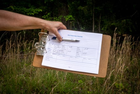 A woman’s hand holding a checklist and pen.