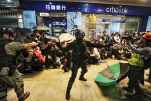 Riot police detain protesters.