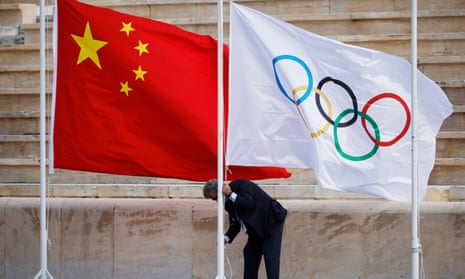 The flags of China and the Olympics are seen being raised before the handover ceremony in Athens