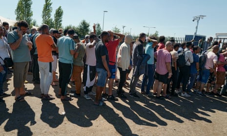 Lines of asylum seekers stand outside centre in the Netherlands