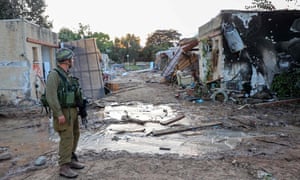 Israeli troops search the scene of a rocket attack in the Israeli kibbutz of Kfar Aza on the border with the Gaza Strip.