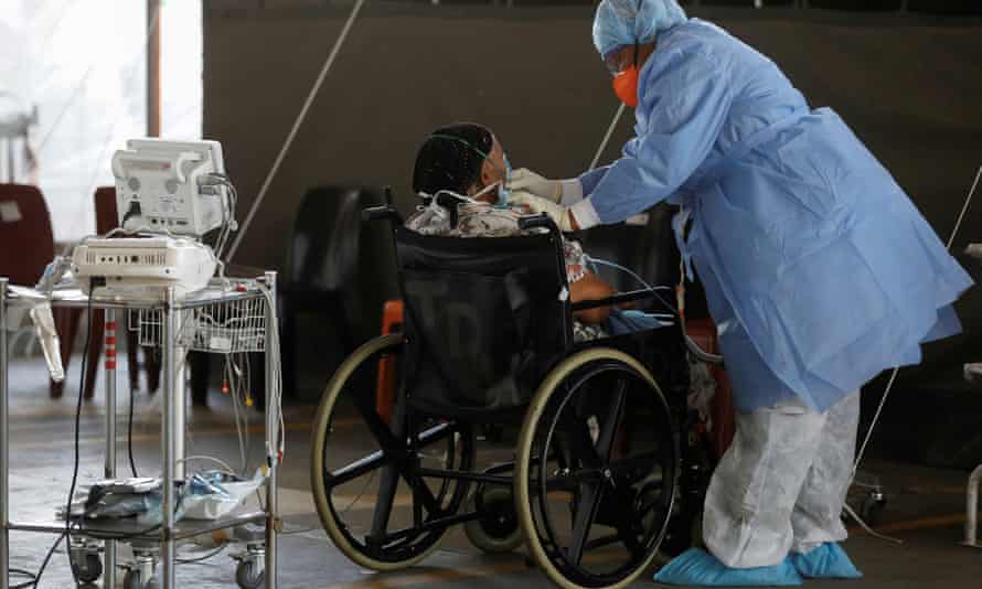 Un travailleur de la santé s'occupe d'un patient à l'hôpital universitaire Steve Biko de Pretoria, en Afrique du Sud.