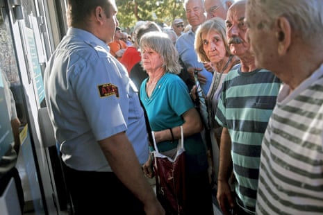 People line up outside a National Bank branch in Athens - as banks opened this morning.