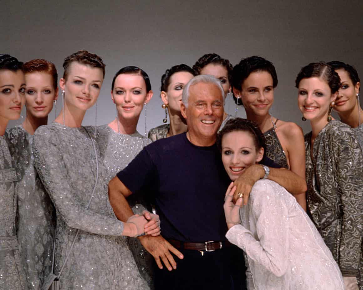 Giorgio Armani poses for photographs with a group of models