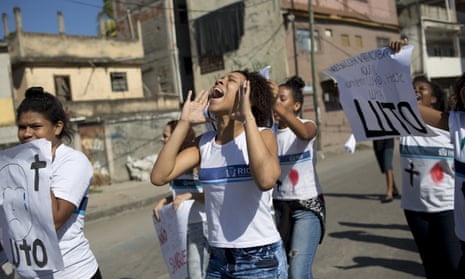 Students and friends of Marcus da Silva hold signs that read ‘Mourning’ during a protest in Rio de Janeiro on 21 June. 
