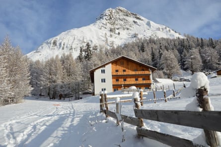 Large chalet in snow with mountain behind