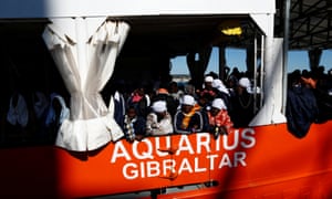 Migrants wait to disembark from the Aquarius on 18 December