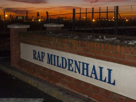 Sign for RAF Mildenhall with planes in background, at sunrise or sunset
