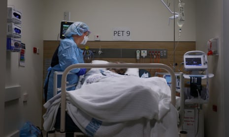 A nurse standing over a patient in a hospital bed