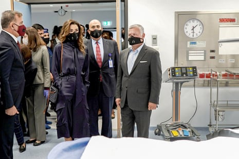 A handout picture released by the Jordanian Royal Palace on 16 August, 2020 shows Jordanian King Abdullah II (C-R) accompanied by his wife Queen Rania (C-L), as they and their entourage are clad in masks due to the coronavirus pandemic, while inaugurating a new emergency hospital in the capital Amman.