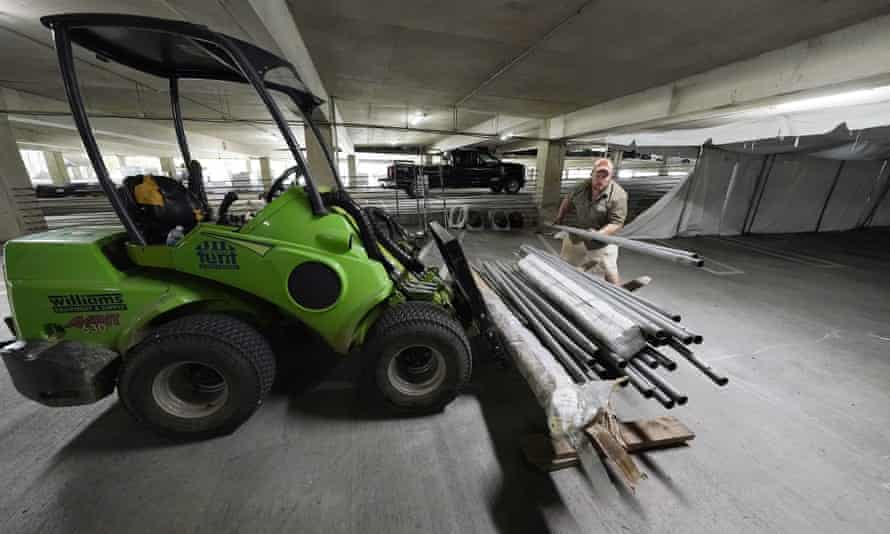 Jay McCullough of Mississippi Tent, arranges tent poles onto a “tent ox” mover as a team of event specialists start to convert a parking garage at the University of Mississippi Medical Center into a field hospital, Wednesday, Aug. 11, 2021, in Jackson, Miss. The current wave of the Delta variant of COVID-19 is overburdening the hospital, causing them to make the conversion to a temporary field hospital, capable of handling 50 beds. In addition, the Level 1 trauma care facility is receiving temporary federal medical personnel to augment the Medical Center’s staff. (AP Photo/Rogelio V. Solis)