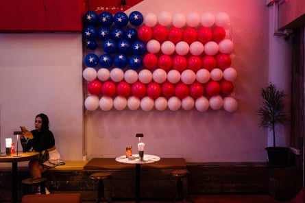 A bar with a US flag made of balloons on the wal.