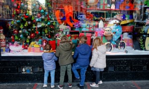 Children look at a window display at the ‘Les Galeries Lafayette’ department store illuminated for Christmas and New Year celebrations.