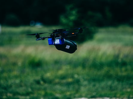 A drone flies low over grass