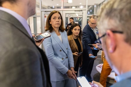 a woman looks at a man holding a phone in her direction