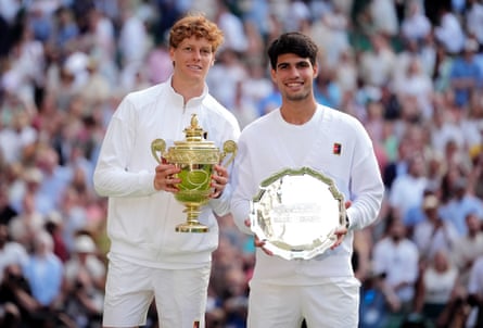 Jannik Sinner and Carlos Alcaraz stand side by side with their respective winner and runner-up trophies after the final of Wimbledon earlier this year.