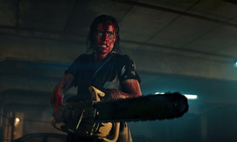 A woman is covered in blood as she holds a chainsaw out menacingly.