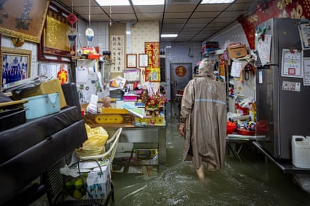 A resident wearing a raincoat in a flooded home