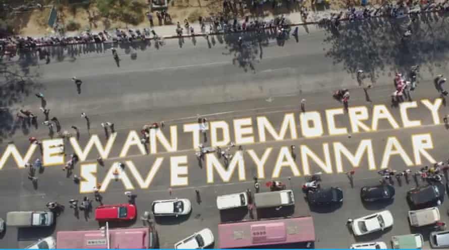 Aerial shot of mural on Yangon street reading ‘We Want Democracy’