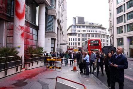 Onlookers gathering near the London office after the red paint protest in 2024.