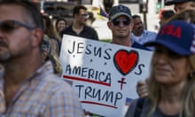 Trump supporters. One is carrying a placard that reads: 'Jesus loves Trump and America'; others are wearing baseball caps with 'USA' and similar logos