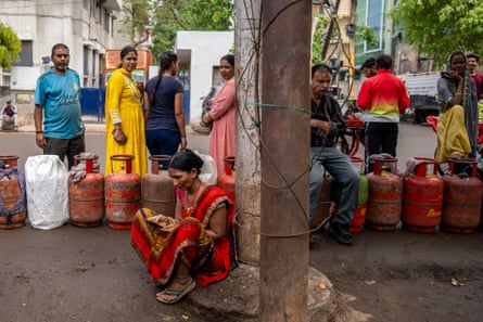 People queue to refill their empty LPG gas cylinders