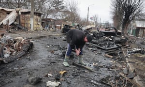 Man looks through rubble in Ukraine